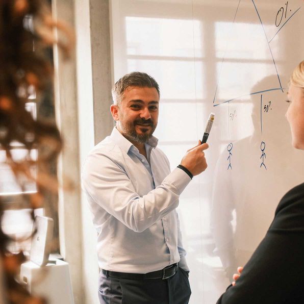 Foto: Steuerberater Serkan Tuncaloglu präsentiert Ergebnisse vor Whiteboard